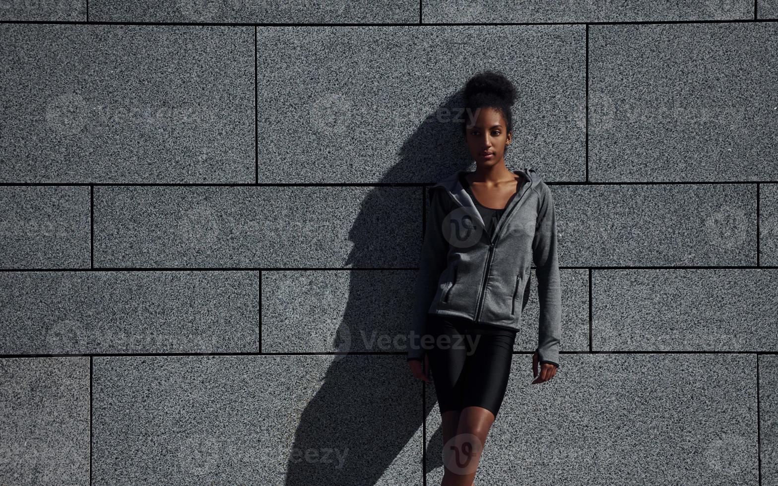 Young african american woman in sportive clothes have workout outdoors at daytime photo