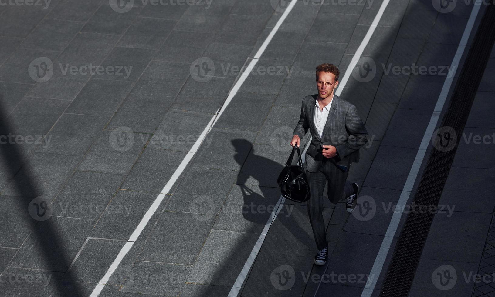 vista desde arriba. un joven hombre de negocios con ropa formal gris está al aire libre en la ciudad foto