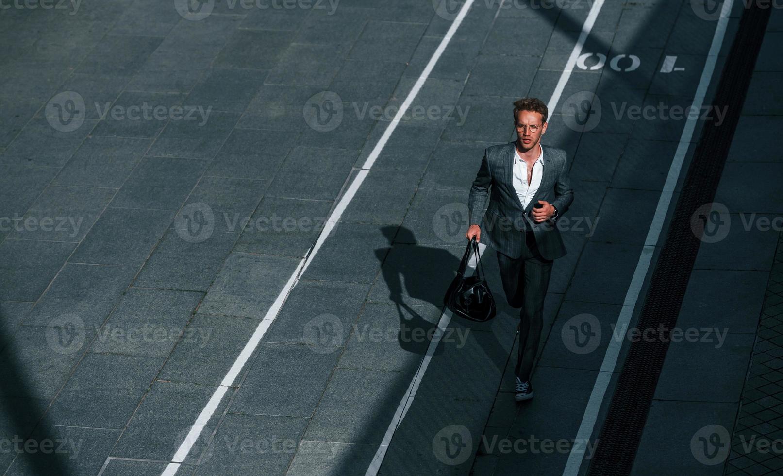 vista desde arriba. un joven hombre de negocios con ropa formal gris está al aire libre en la ciudad foto