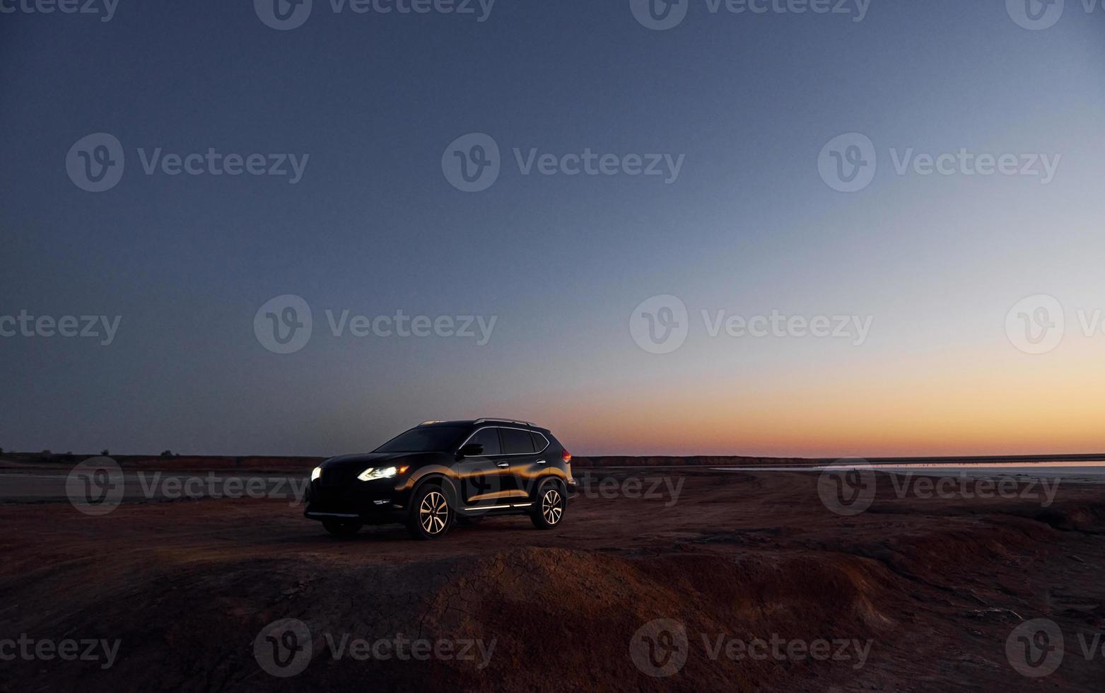 Distant view of modern black automobile that is on the coast photo