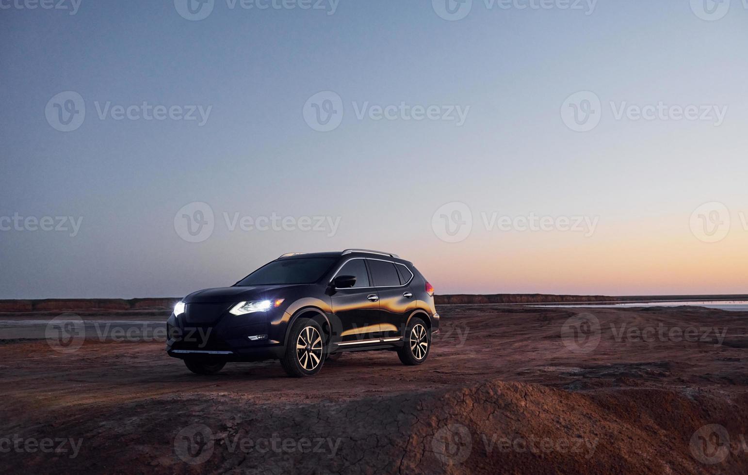 Distant view of modern black automobile that is on the coast photo