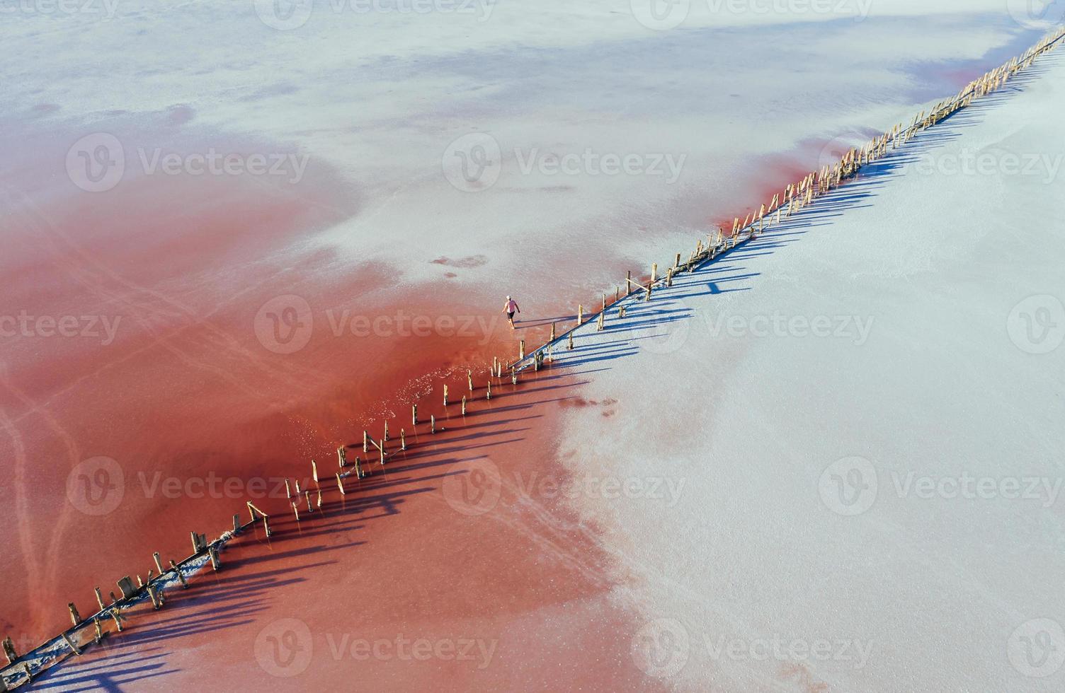 el hombre camina cerca del borde de madera. vista aérea de majestuosos paisajes de la isla de jarilgach en ucrania foto