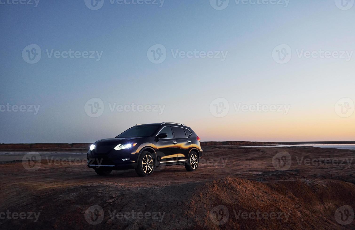 Distant view of modern black automobile that is on the coast photo