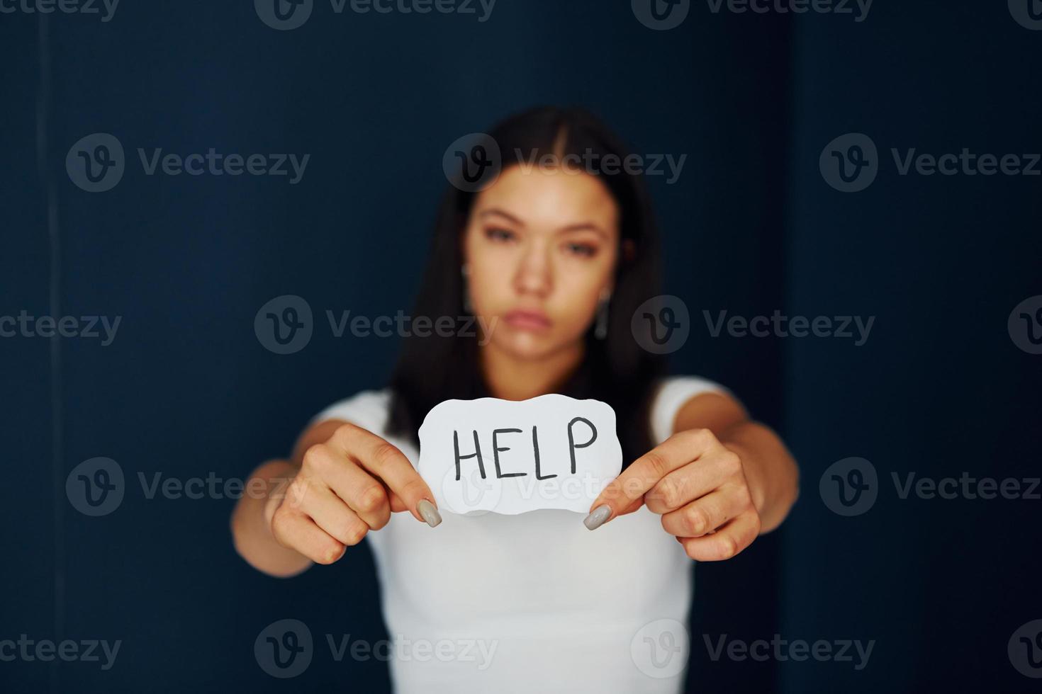 Young scared woman holds sign and ask for help. Conception of domestic violence photo