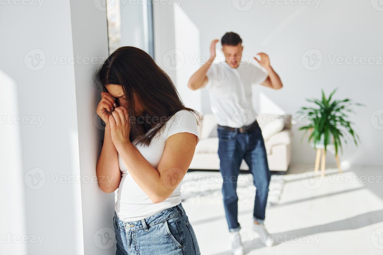 Violent aggressive young man threatening his girlfriend at home photo