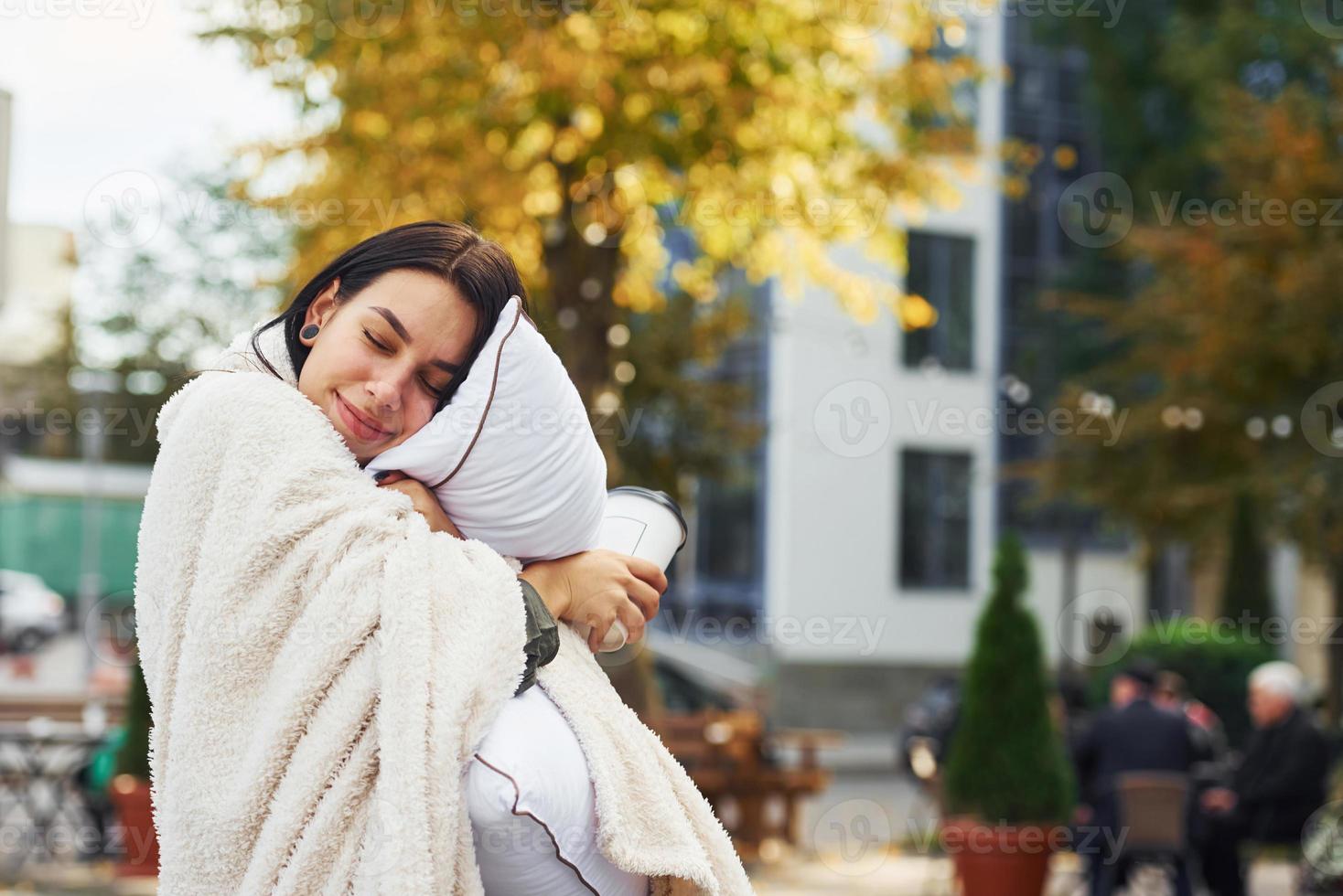 Young woman in pajama is outdoors on the street. Big city photo