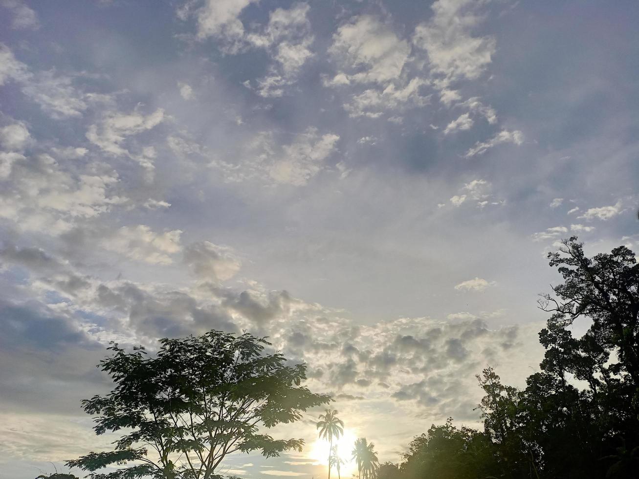 beautiful natural scenery in the blue sky, white clouds and many green trees around it photo