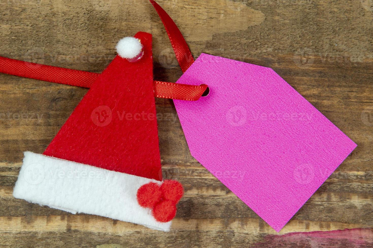 elementos decorativos de navidad junto a la tarjeta con cinta roja y espacio para escribir foto