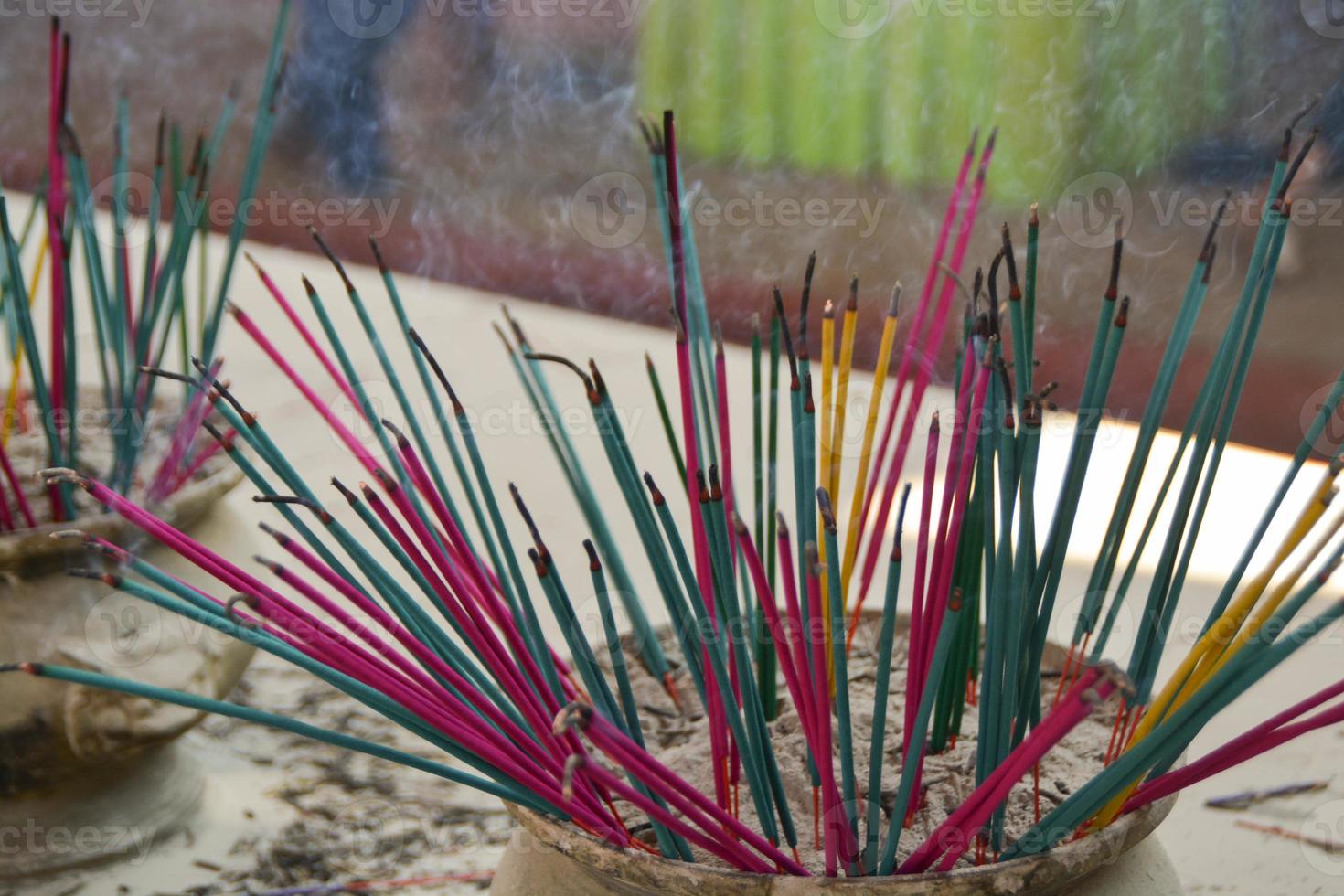 Burning aromatic different color incense sticks inside temple. photo