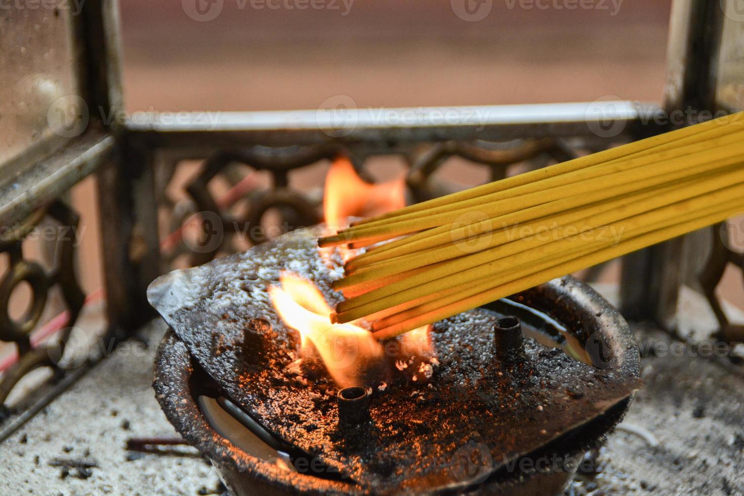 Yellow incense stick was lit by the fire of lanterns. photo