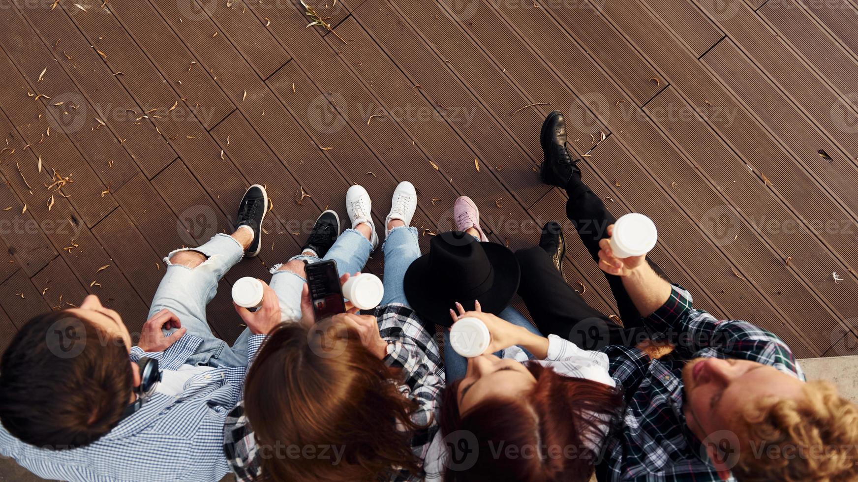 vista superior del grupo de jóvenes amigos alegres que están al aire libre divirtiéndose juntos foto