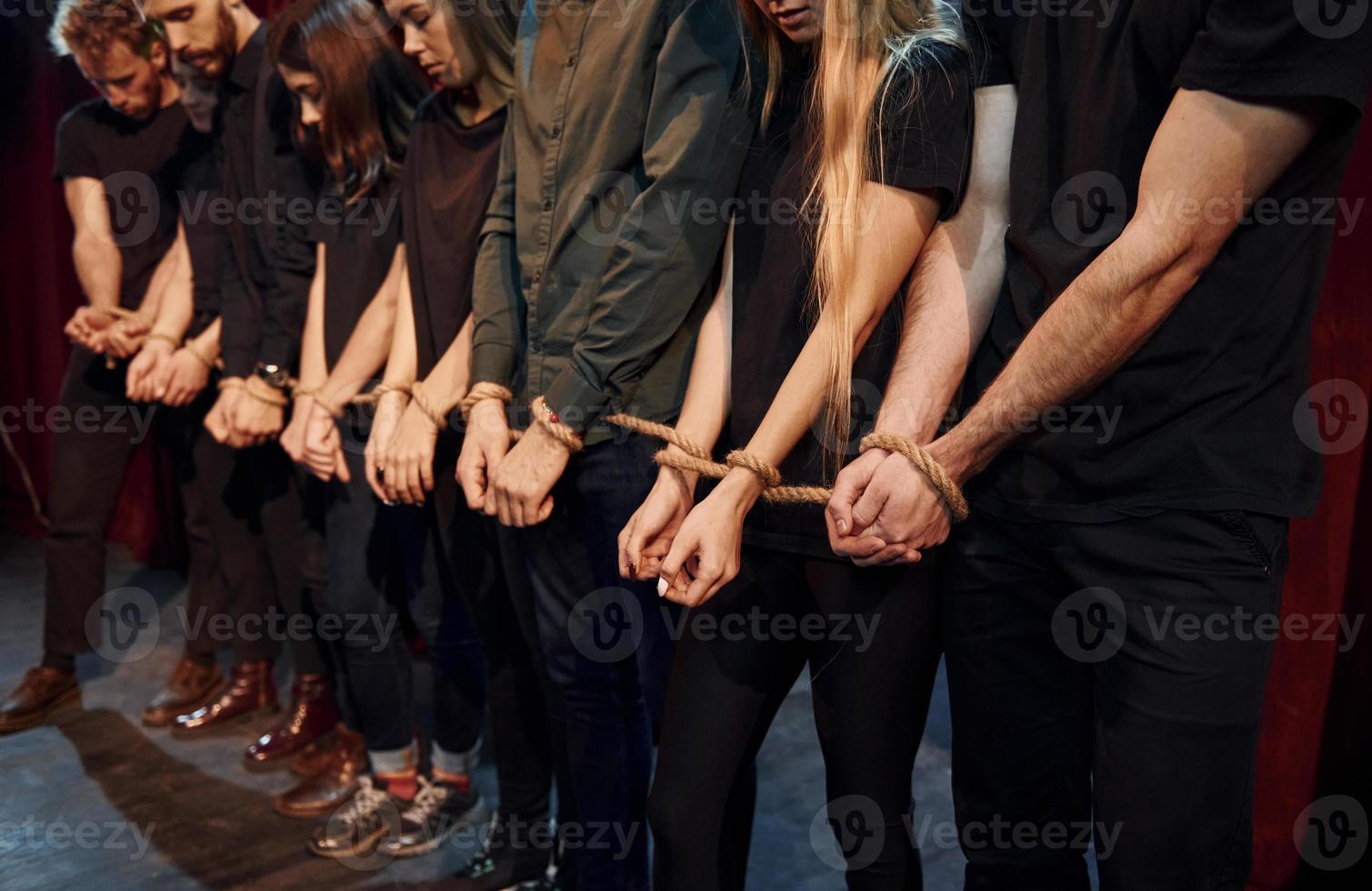 With rope in hands. Group of actors in dark colored clothes on rehearsal in the theater photo