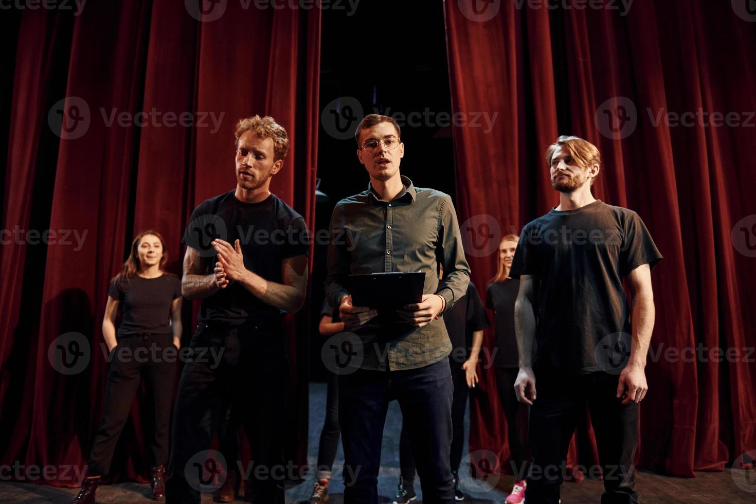 Working together. Group of actors in dark colored clothes on rehearsal in the theater photo