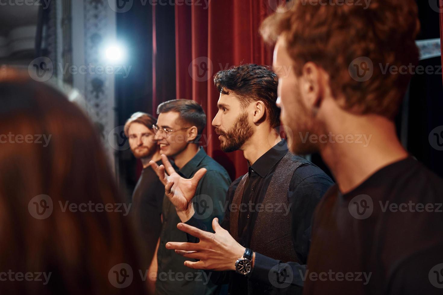 Working together. Group of actors in dark colored clothes on rehearsal in the theater photo