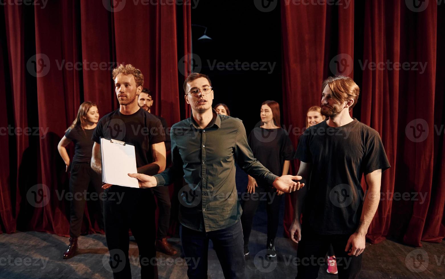 Working together. Group of actors in dark colored clothes on rehearsal in the theater photo