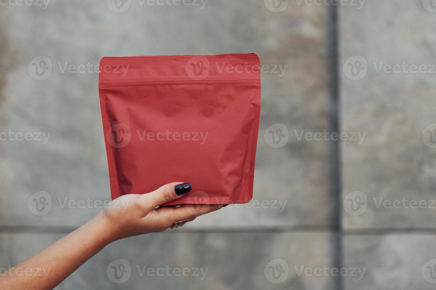 Close up view of woman's hands that holds red package of new coffee photo