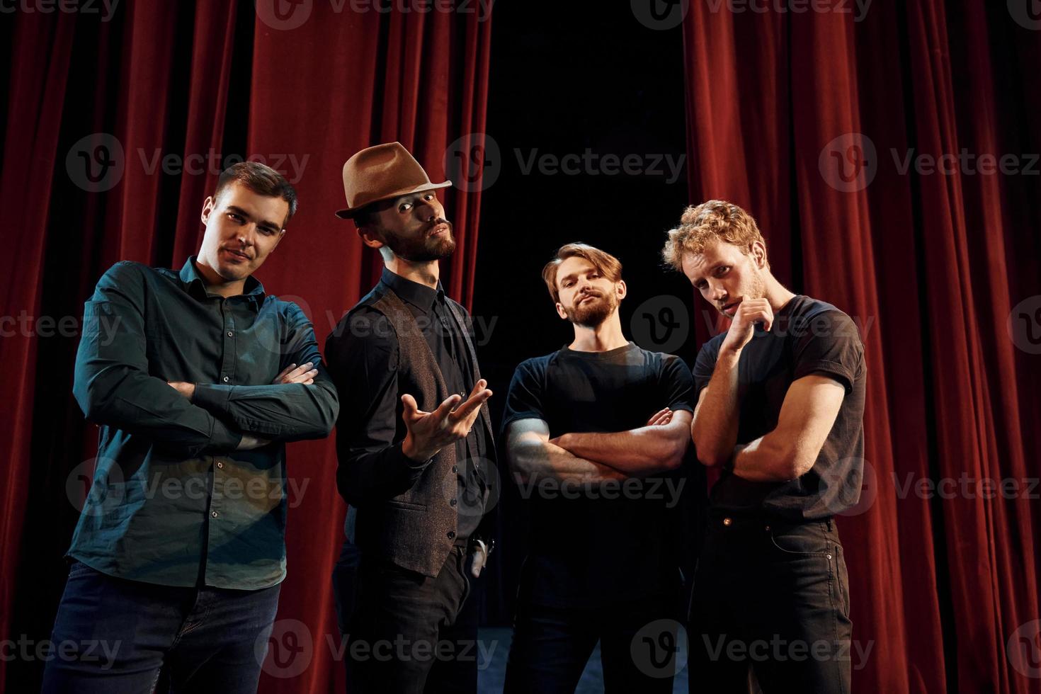 posando para una cámara. grupo de actores con ropa de color oscuro ensayando en el teatro foto