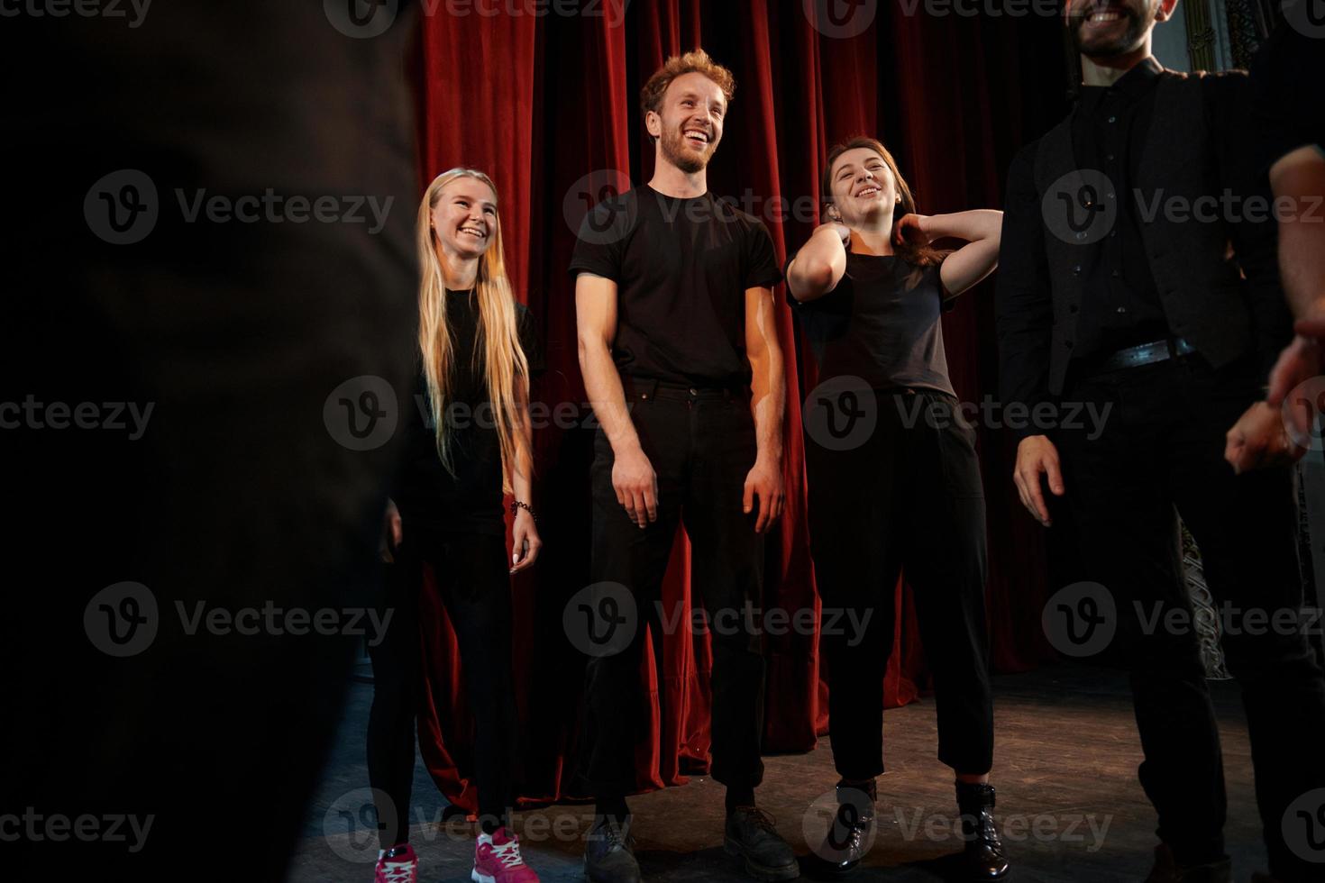 Practice in progress. Group of actors in dark colored clothes on rehearsal in the theater photo