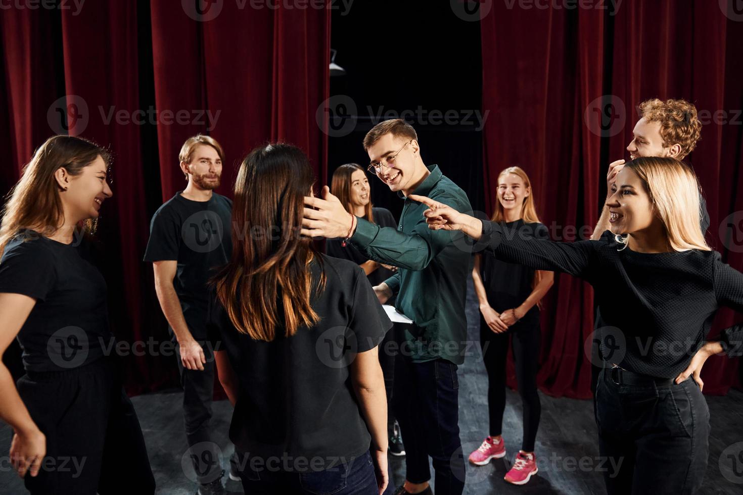 grupo de actores con ropa de color oscuro ensayando en el teatro foto