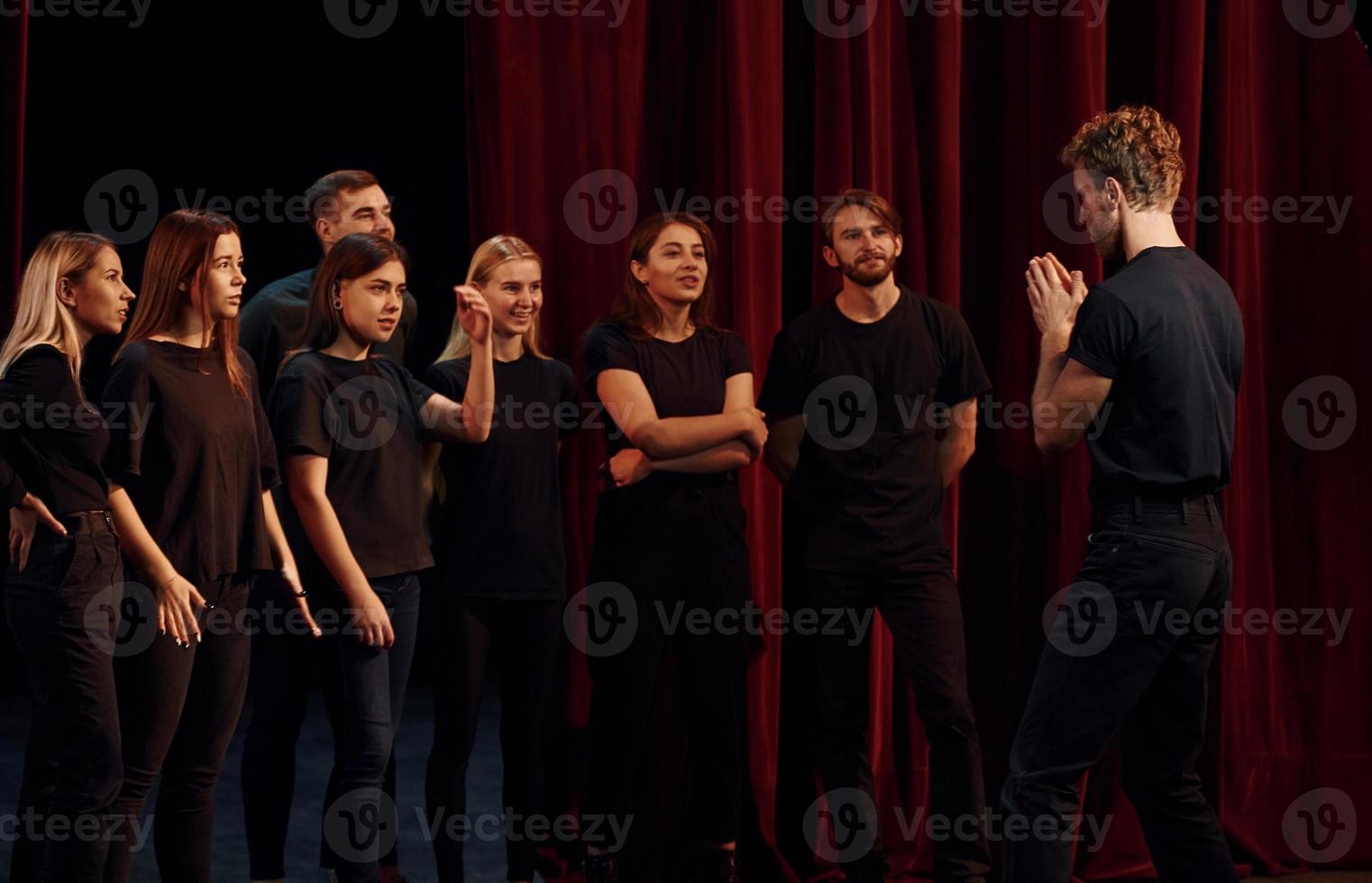 Group of actors in dark colored clothes on rehearsal in the theater photo