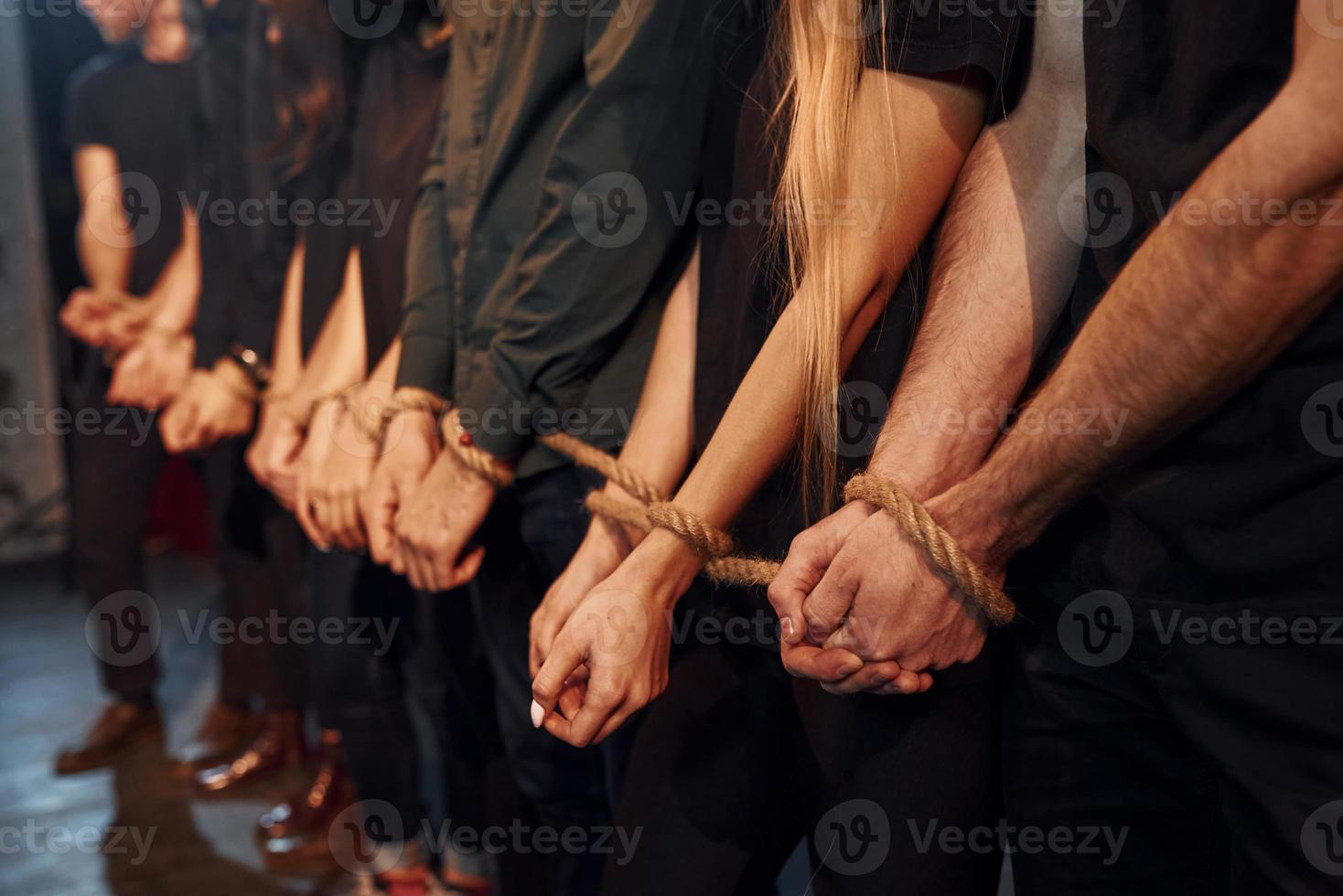 Knot in the hands. Group of actors in dark colored clothes on rehearsal in the theater photo