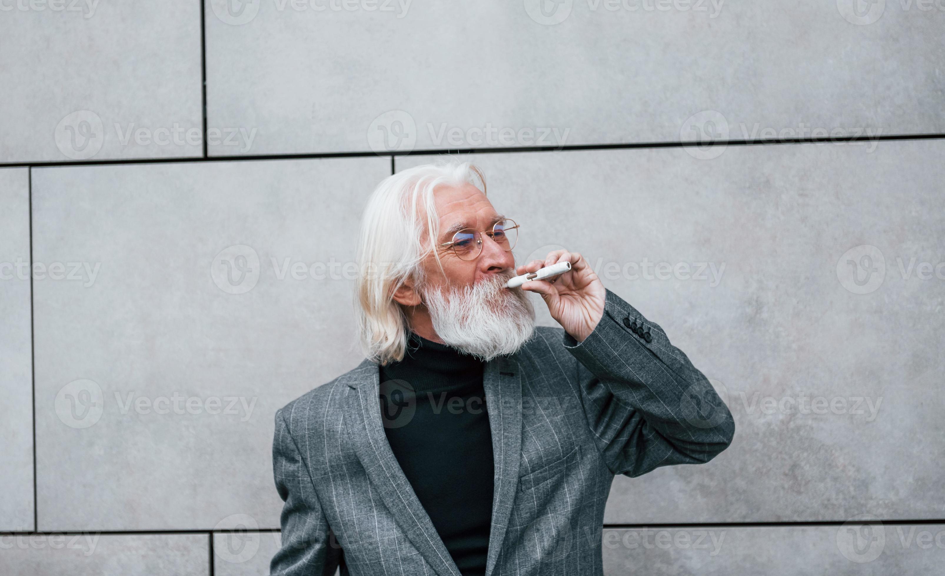 Smoking electronic cigarette. Senior businessman in formal clothes, with grey hair and beard is outdoors 15347248 Stock Photo at Vecteezy Smoking electronic cigarette. Senior businessman in formal clothes, with grey hair and beard is outdoors 15347248 Stock Photo at Vecteezy