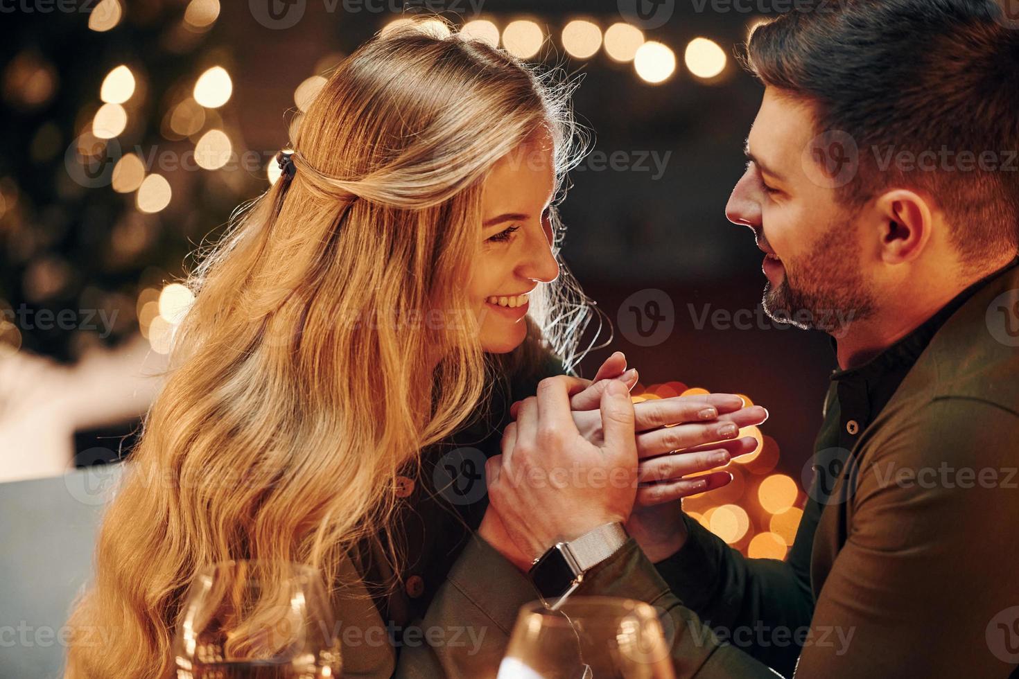 Side view. Young lovely couple have romantic dinner indoors together photo