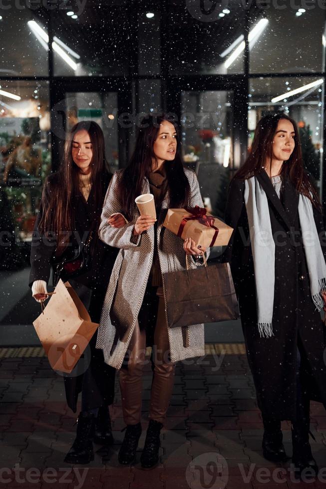 After shopping. Three cheerful women spends Christmas holidays together outdoors. Conception of new year photo