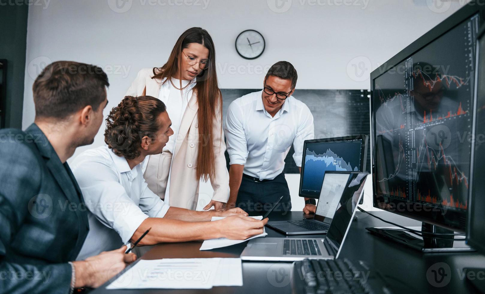 atención a los detalles. equipo de corredores de bolsa trabaja en una oficina moderna con muchas pantallas foto