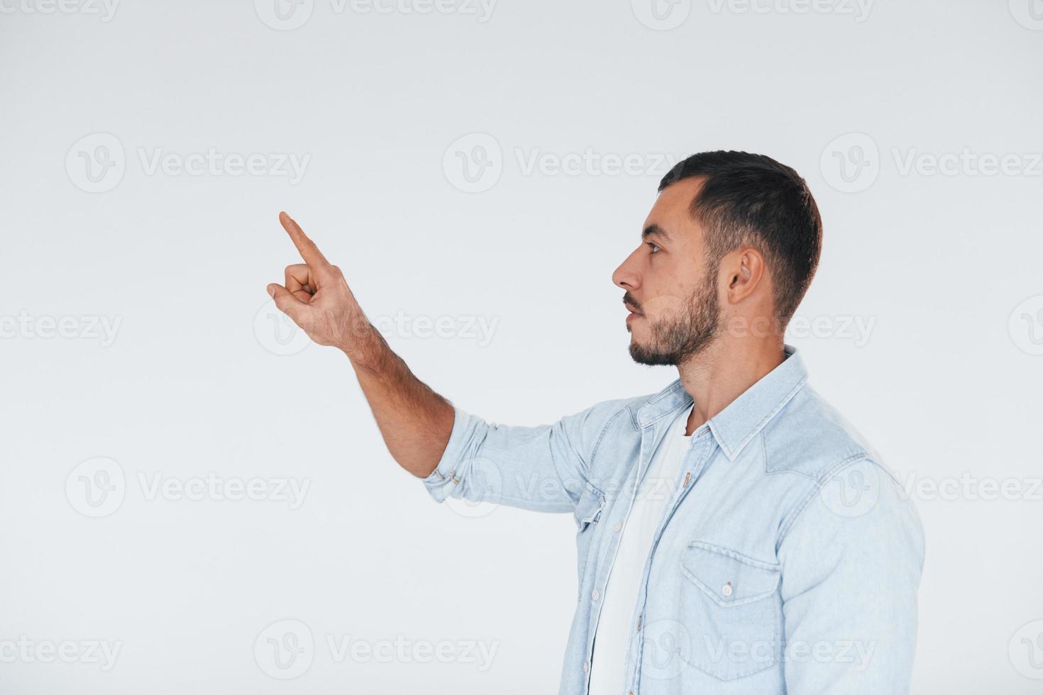 Young handsome man standing indoors against white background photo