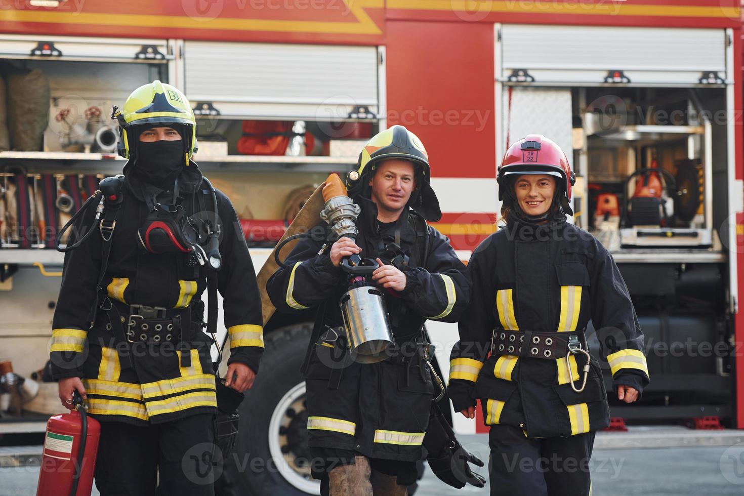 Group of firefighters in protective uniform that outdoors near truck photo