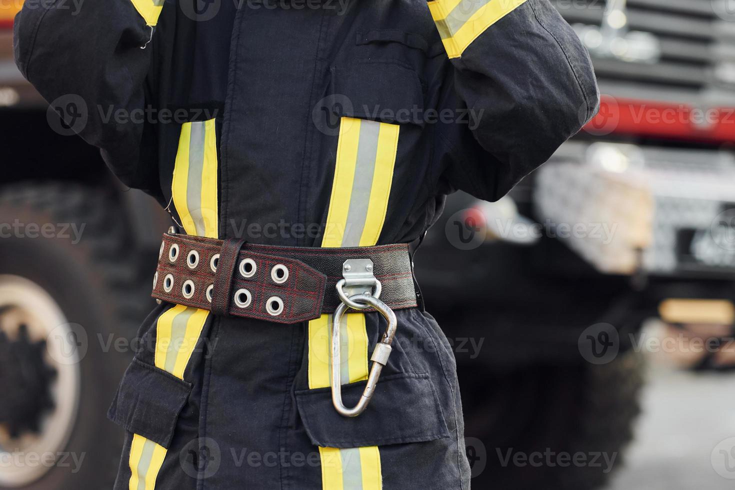 Female firefighter in protective uniform standing near truck photo