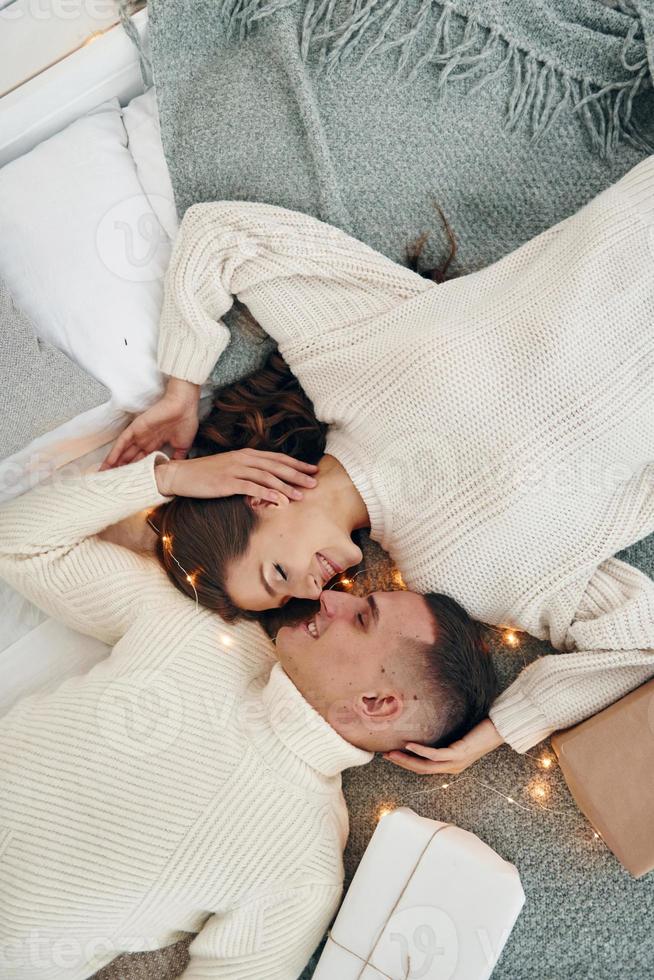Top view of young romantic couple that lying down and celebrates New year together indoors photo