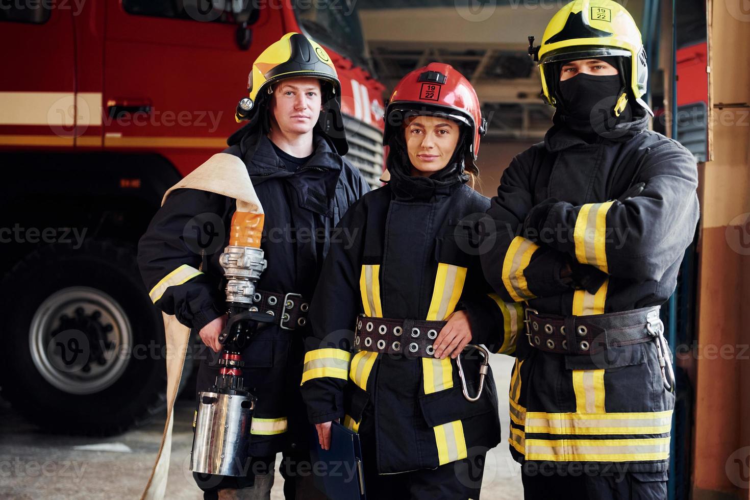 Posing for a camera. Group of firefighters in protective uniform that is on station photo