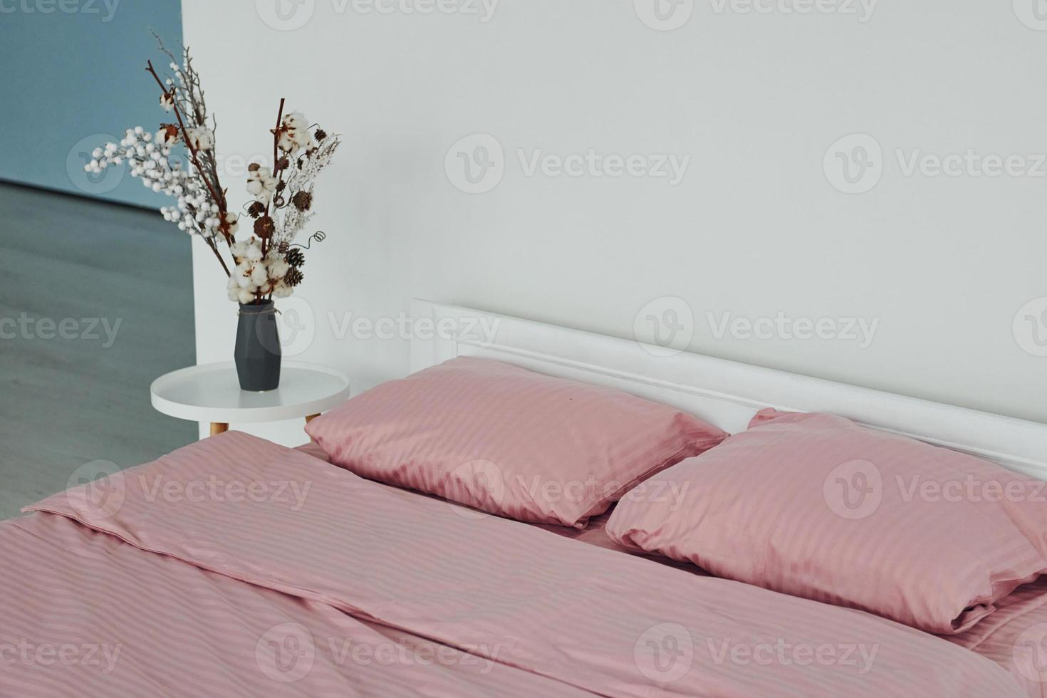 Pink colored bed. Interior and design of beautiful modern bedroom at daytime photo