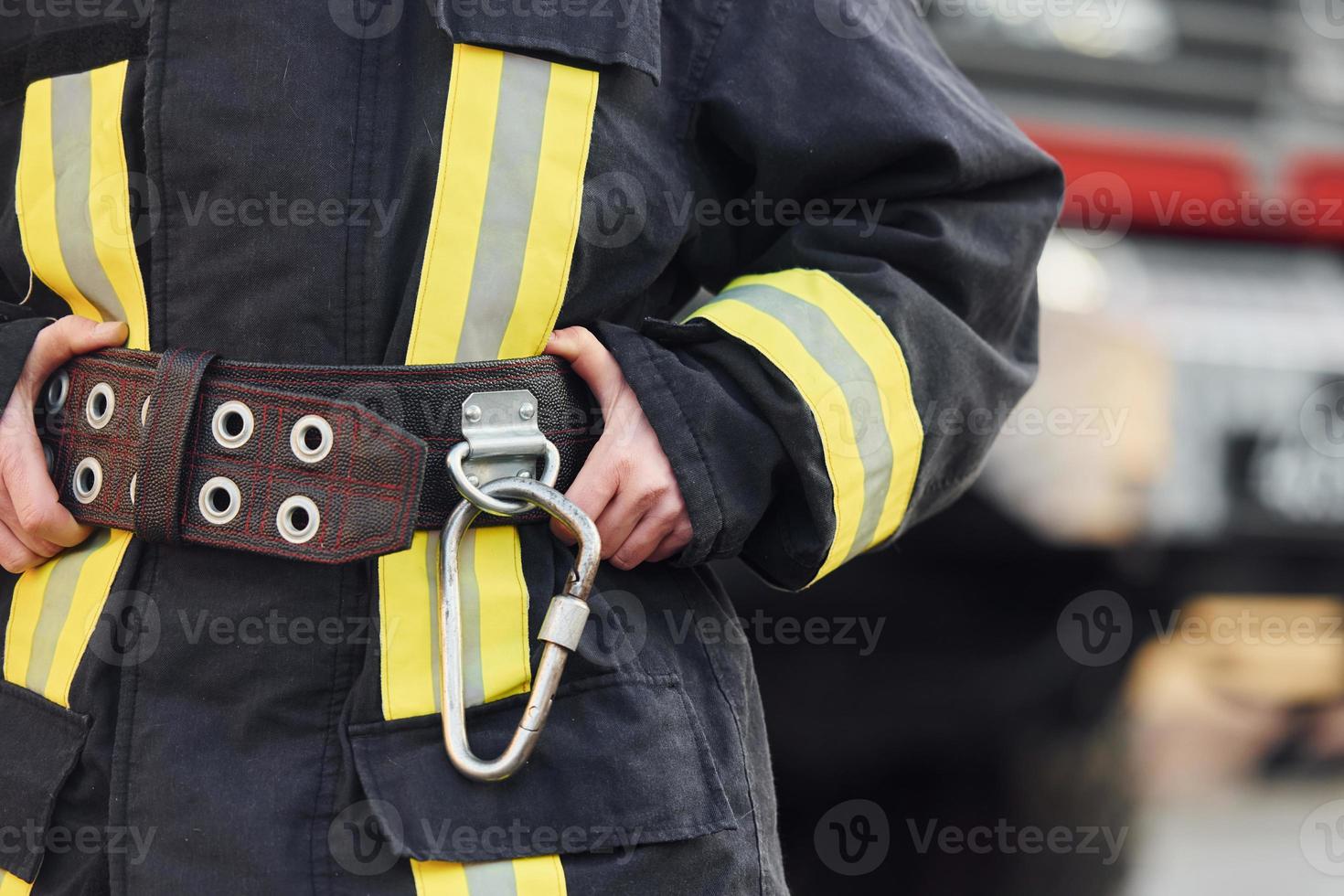 Female firefighter in protective uniform standing near truck photo