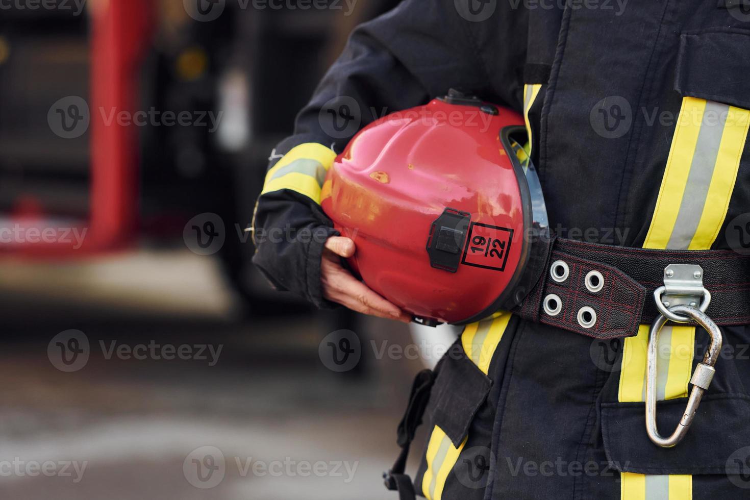 Close up view. Female firefighter in protective uniform standing near truck photo