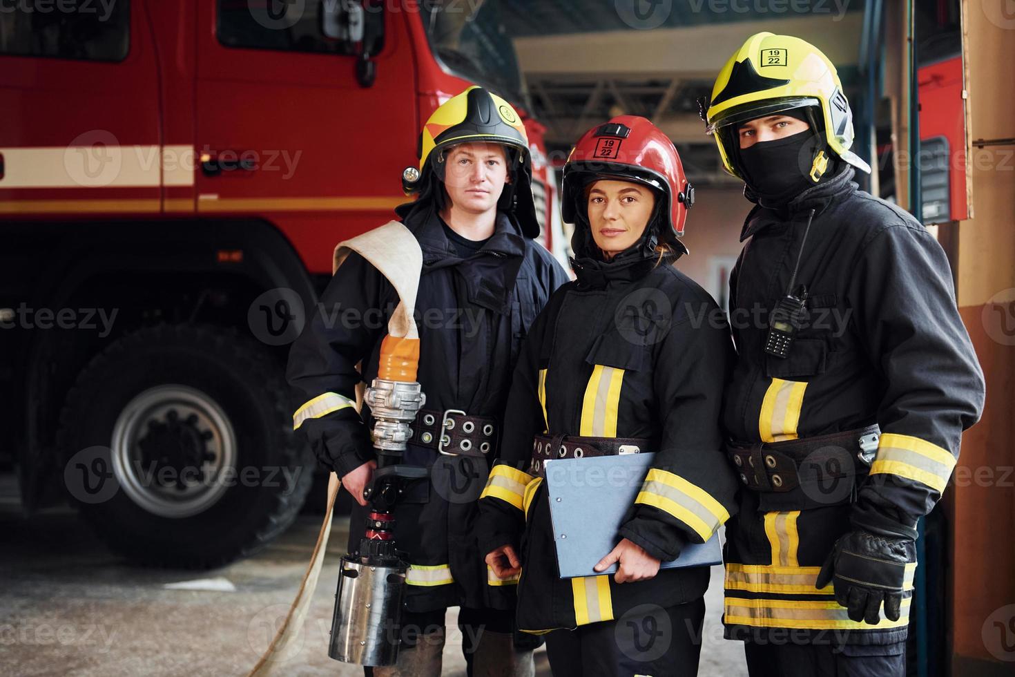 posando para una cámara. grupo de bomberos con uniforme protector que está en la estación foto