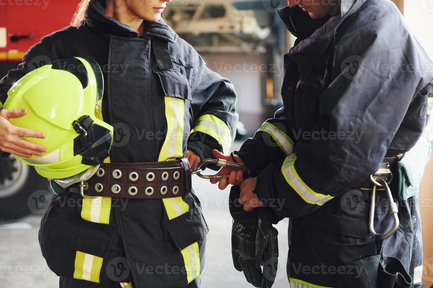 Male and female firefighters in protective uniform standing together photo