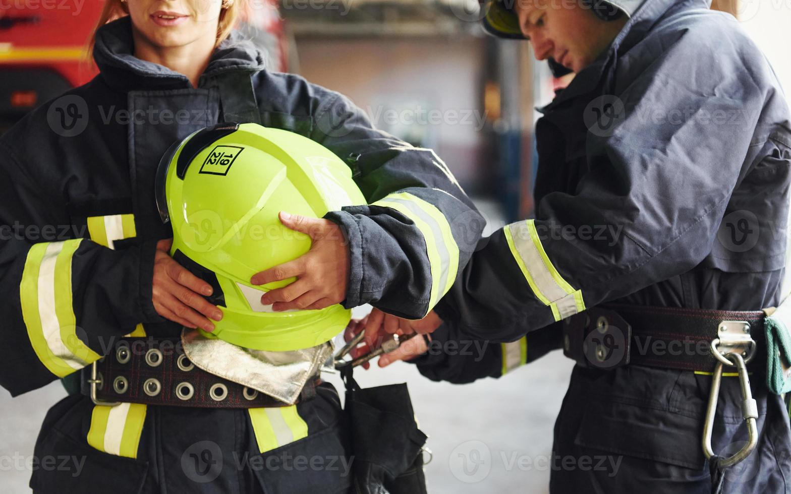 Male and female firefighters in protective uniform standing together photo