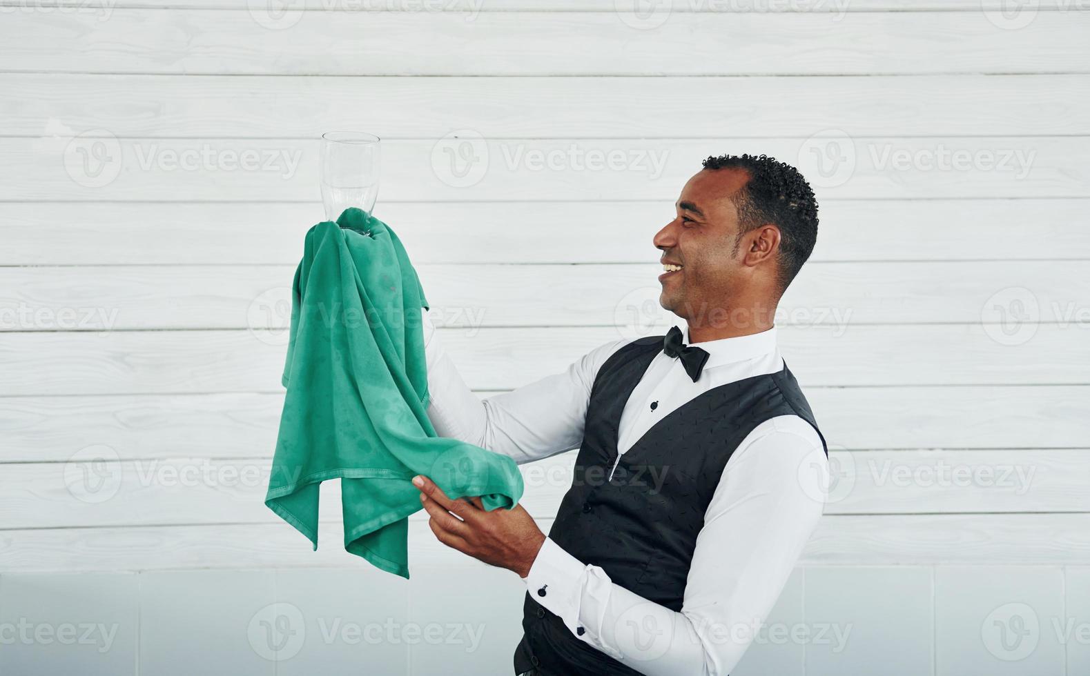 Black waiter in formal clothes is at his work outdoors at sunny daytime photo