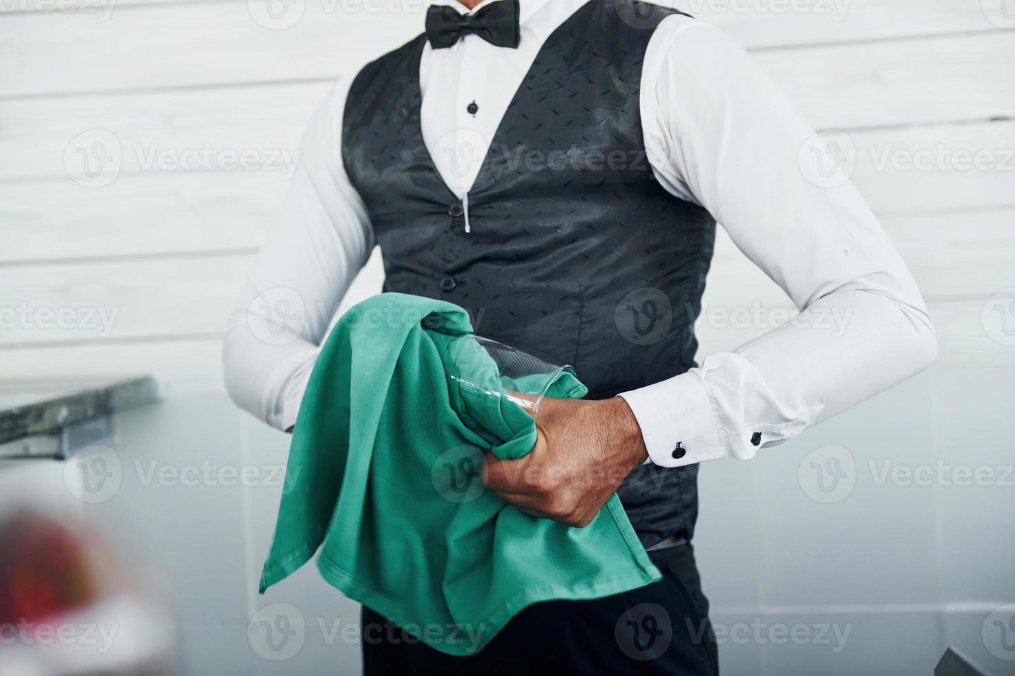 Black waiter in formal clothes is at his work outdoors at sunny daytime photo