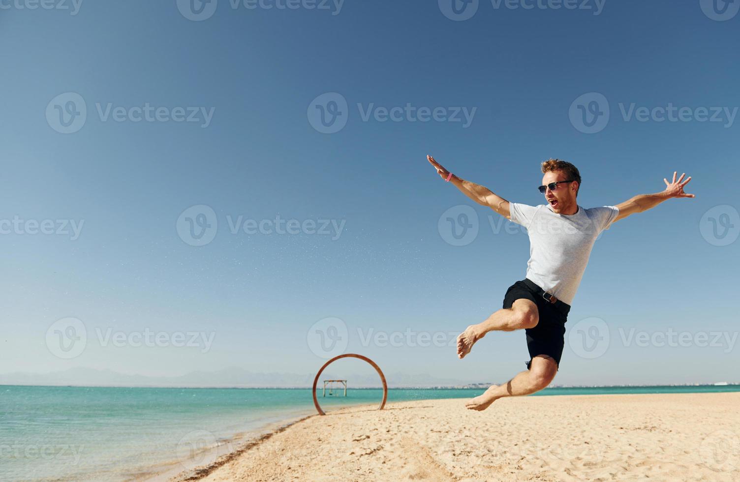 Having fun. Young european man have vacation and enjoying free time on the beach of sea photo