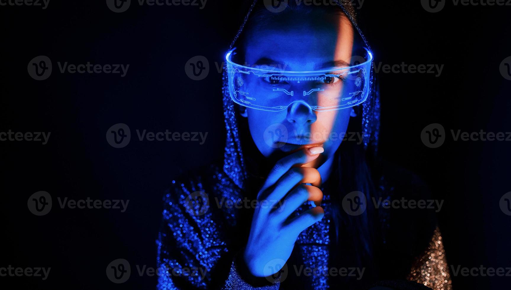 Portrait of young girl that is in eyeglasses in blue neon lighting photo