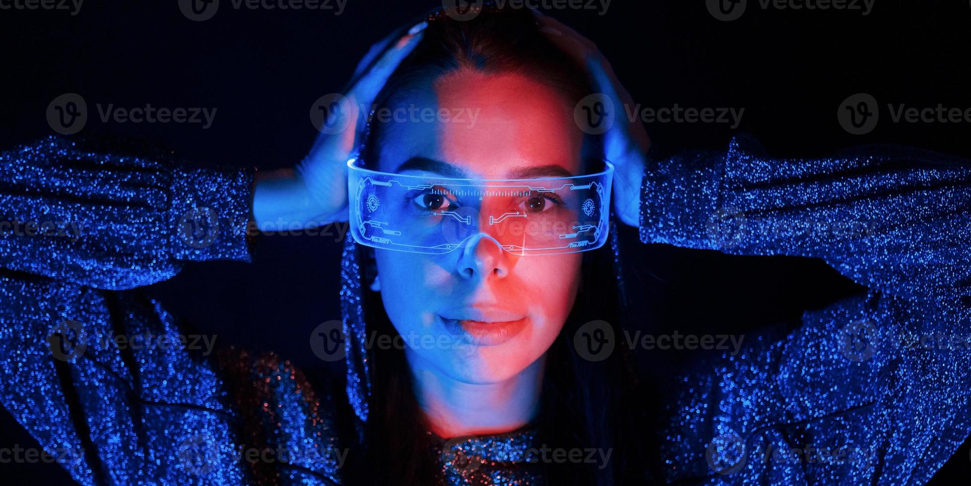 Portrait of young girl that is in eyeglasses in blue neon lighting photo