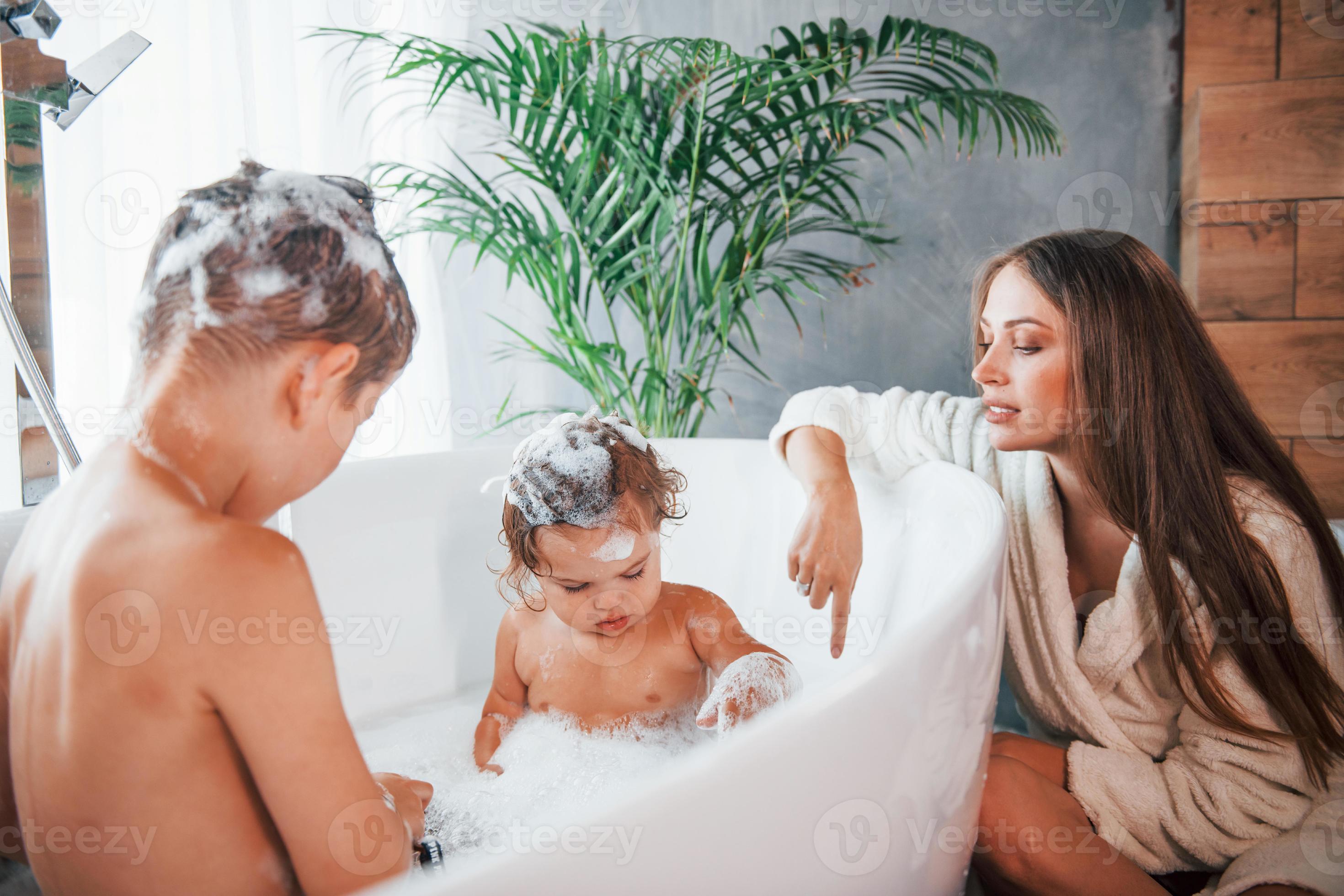 Having Fun Young Mother Helps Her Son And Daughter Two Kids Washing how-long-to-wait-to-give-baby-first-bath-baby-viewer