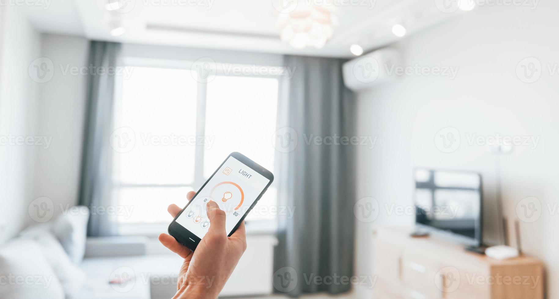 Close up view of man that is indoors controlling smart home technology photo