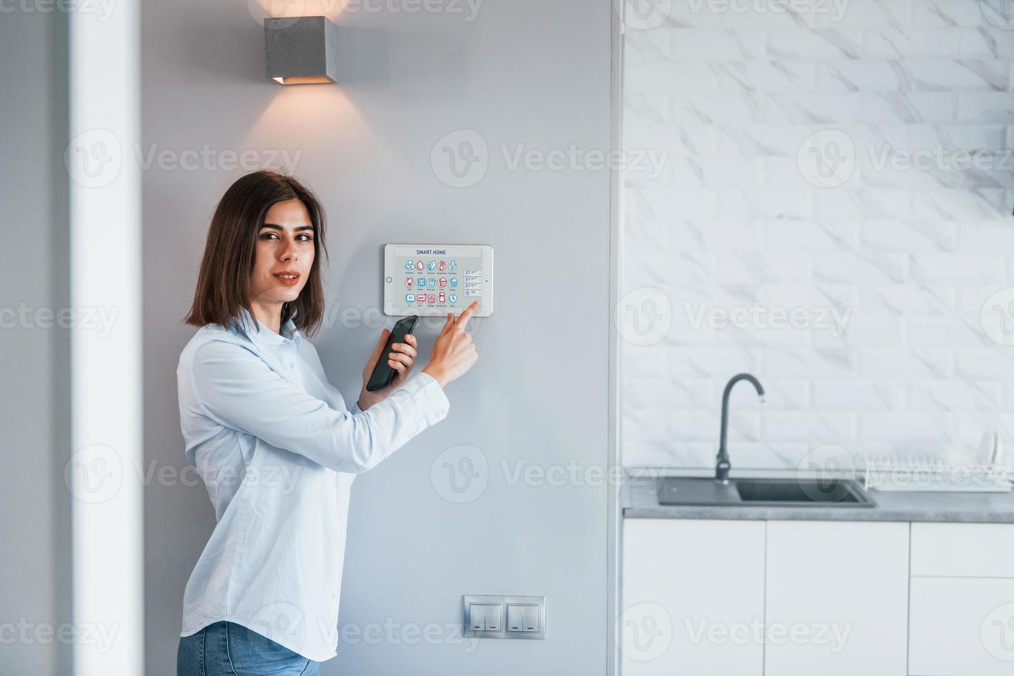 Woman is indoors controlling smart home technology photo