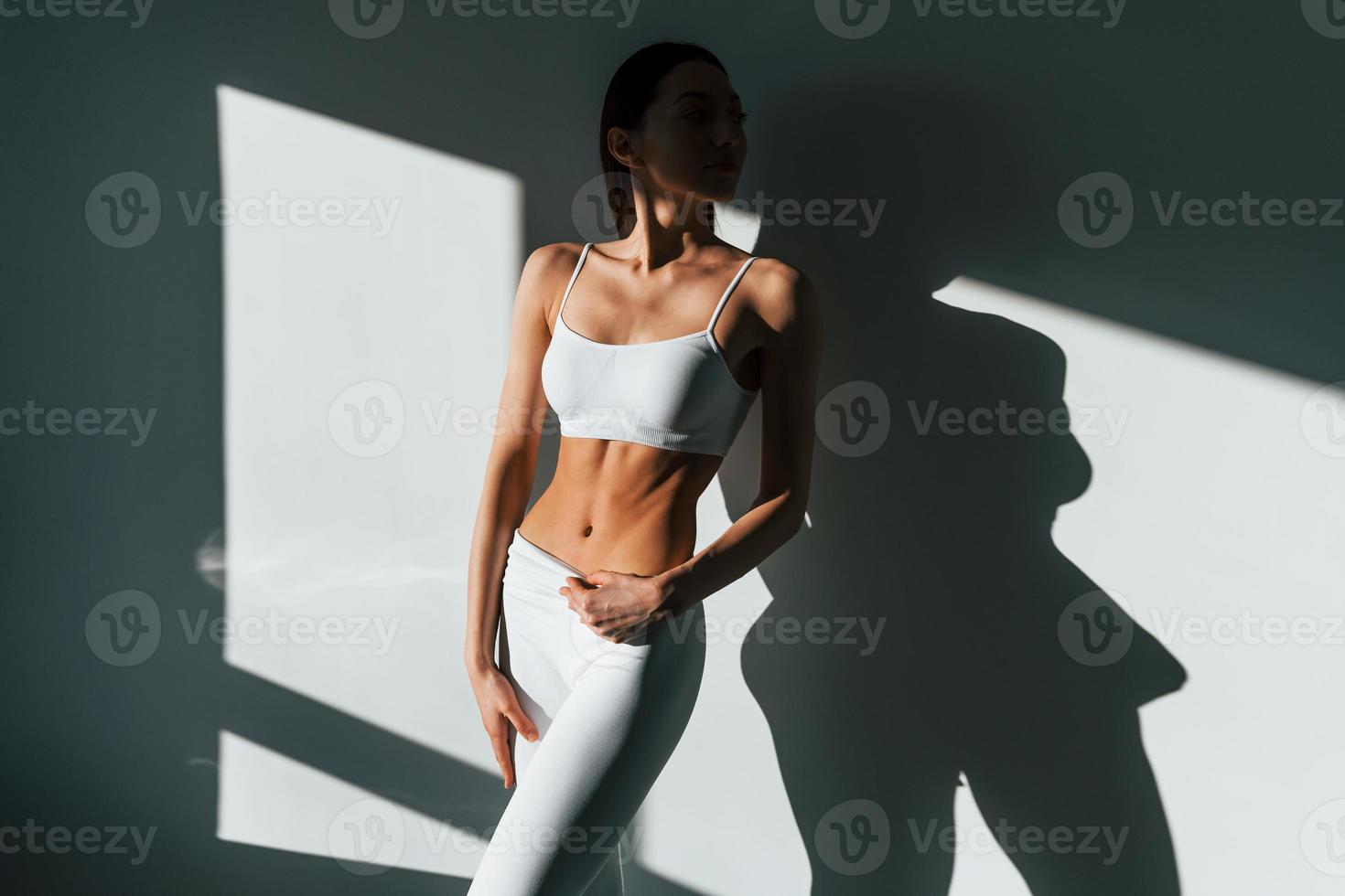 hermosa iluminación. joven mujer caucásica con forma de cuerpo delgado está en el interior durante el día foto