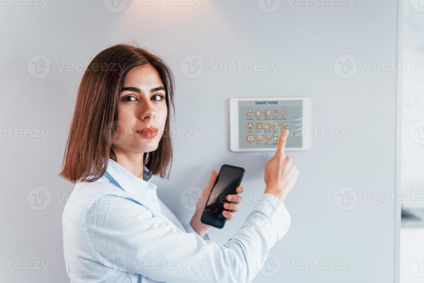 Woman is indoors controlling smart home technology photo